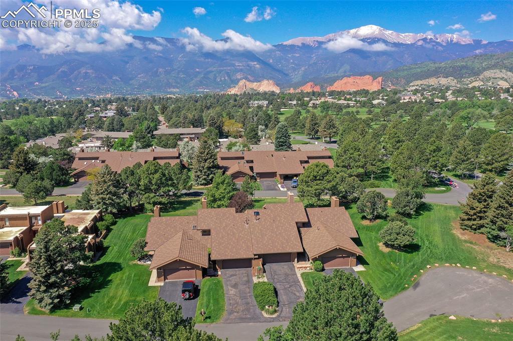 Image 21 of 25: Aerial view of property and surrounding area with mountains and nearby subu