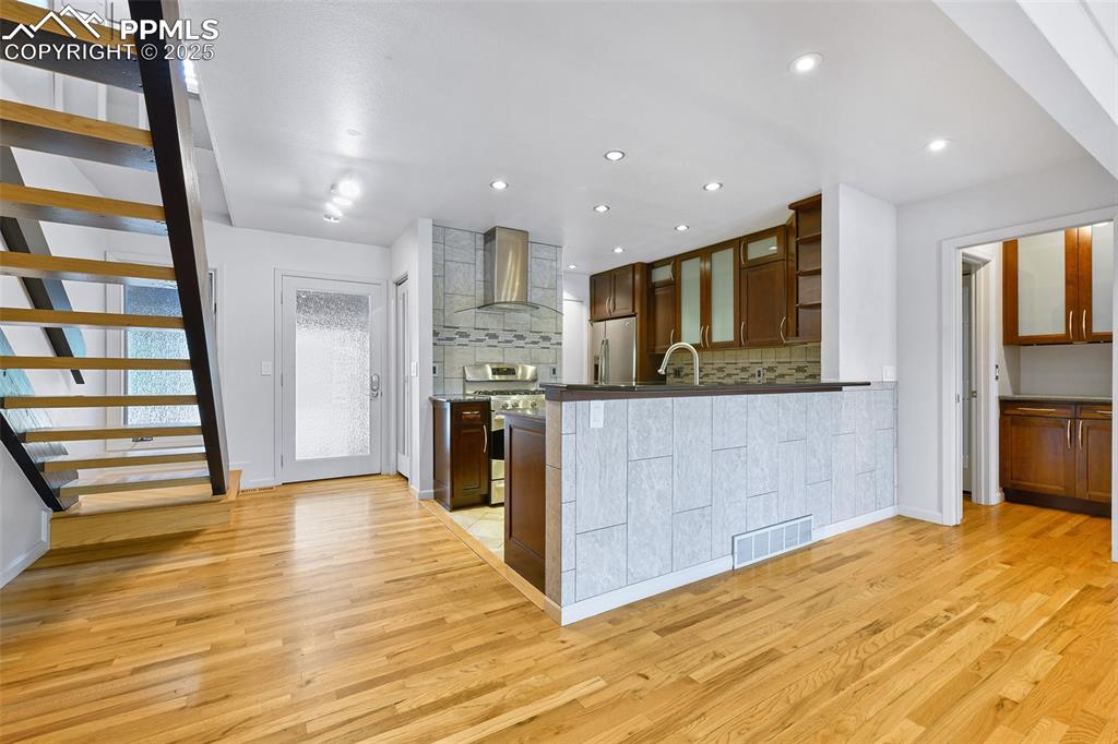 Image 3 of 25: Kitchen with wall chimney range hood, appliances with stainless steel finis