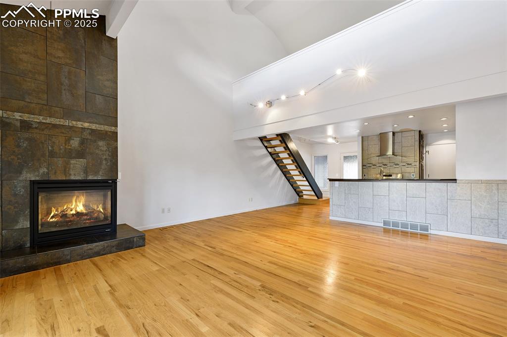 Image 5 of 25: Unfurnished living room featuring light wood finished floors, a fireplace,