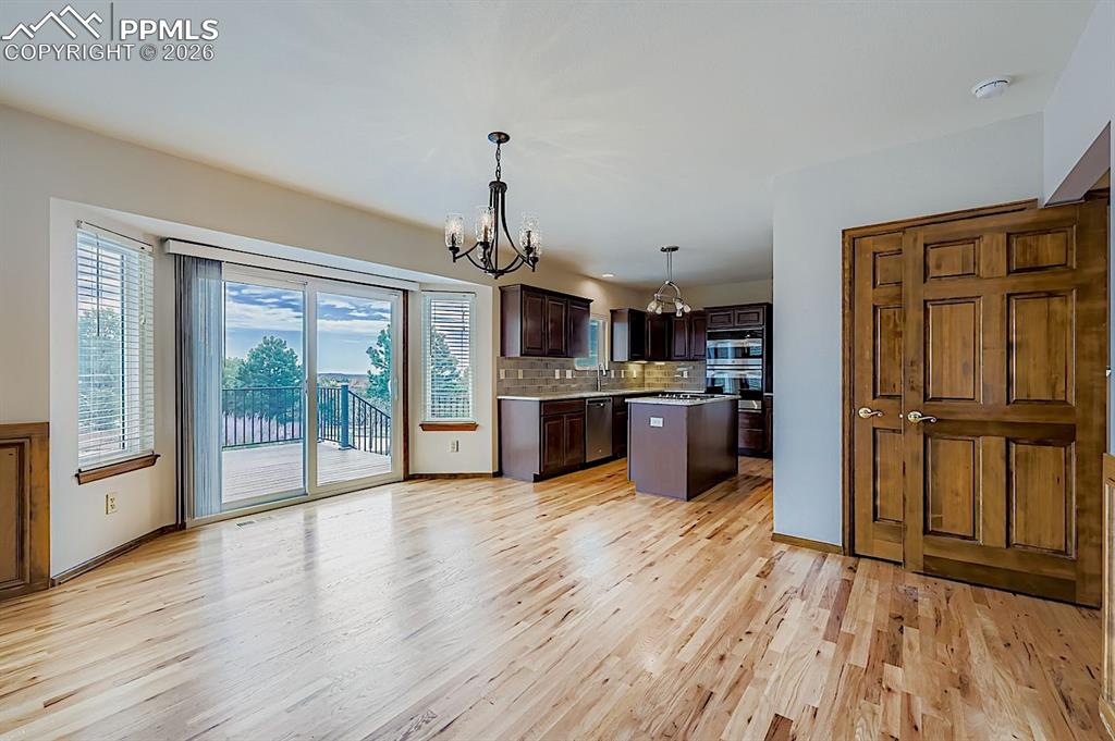 Image 16 of 48: Kitchen with dark brown cabinetry, tasteful backsplash, pendant lighting, a
