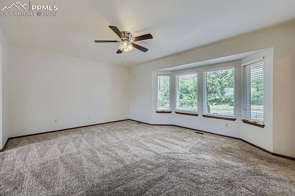 Image 7 of 48: Empty room with carpet and ceiling fan