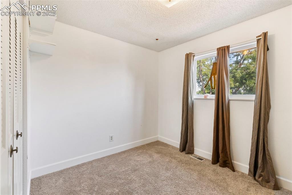 Image 10 of 32: Spare room with light colored carpet and a textured ceiling