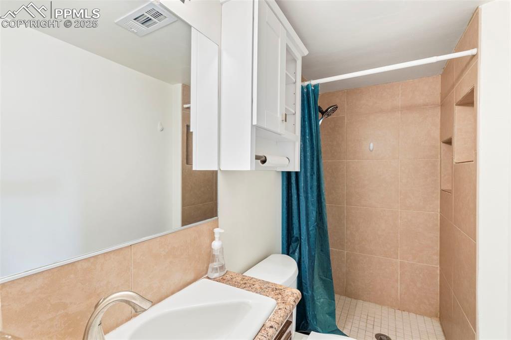 Image 18 of 32: Bathroom featuring a shower stall and vanity
