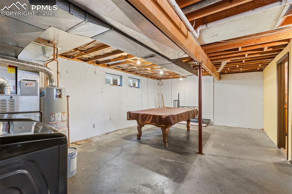 Image 19 of 32: Basement with billiards table, washer / clothes dryer, gas water heater, an