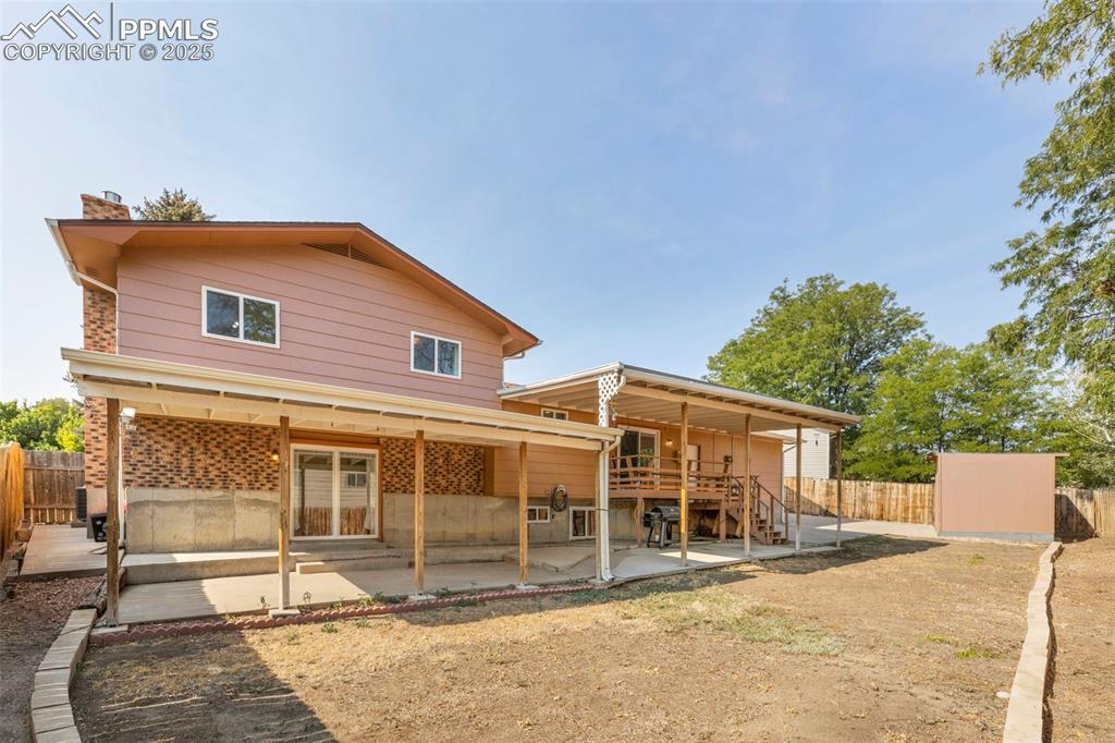 Image 24 of 32: Back of property featuring a patio area, a fenced backyard, and a chimney