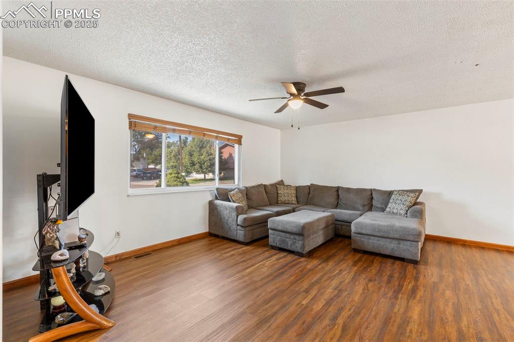 Image 4 of 32: Living area featuring a textured ceiling, wood finished floors, and a ceili