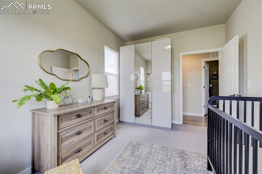 Image 14 of 50: Bedroom with light colored carpet and baseboards