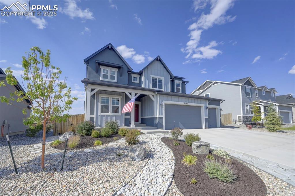 Image 2 of 50: Craftsman-style house featuring board and batten siding, a porch, concrete