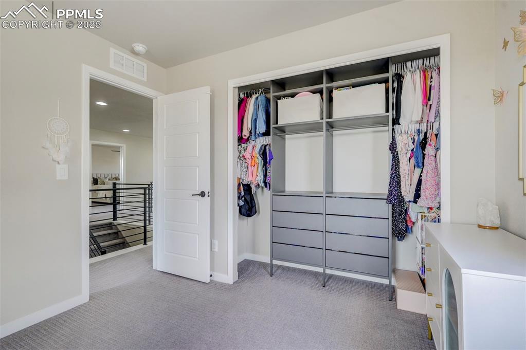 Image 27 of 50: Bedroom with light colored carpet and a closet