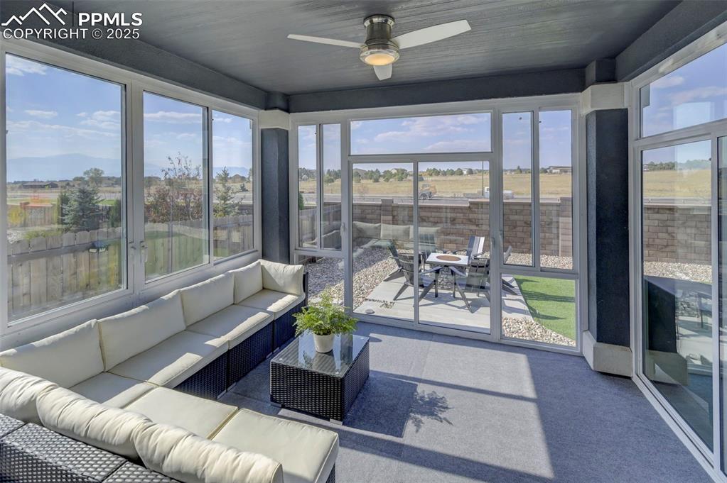 Image 39 of 50: Sunroom with a ceiling fan, outdoor lounge area, and outdoor dining space