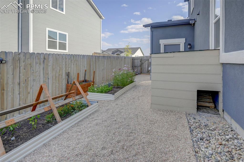 Image 50 of 50: Fenced backyard featuring a garden