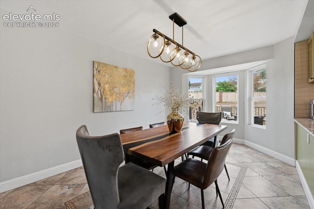 Image 12 of 50: Dining room looks out to the gorgeous deck!