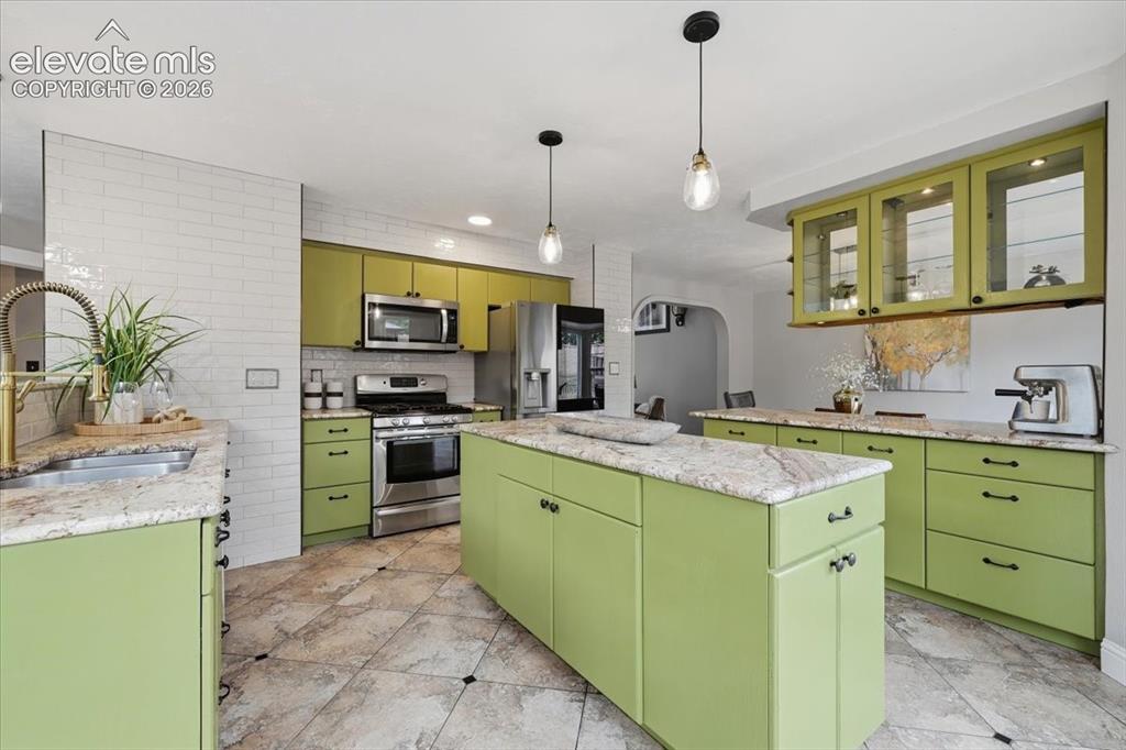 Image 14 of 50: Huge kitchen with tile walls, upgraded faucet and stainless steel appliance