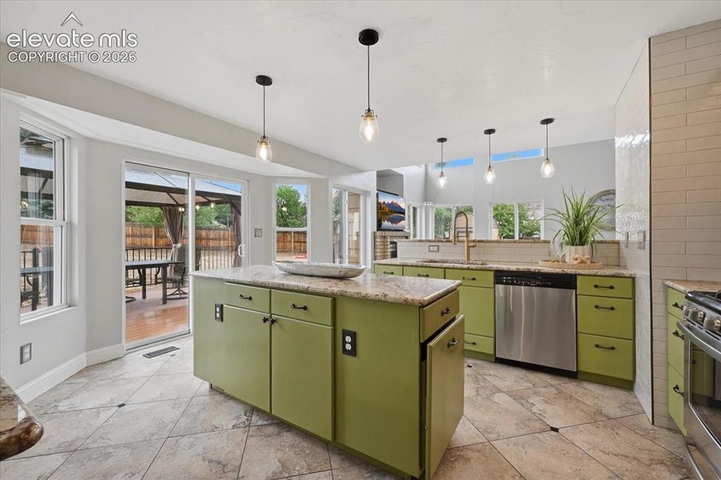 Image 15 of 50: Granite counters and full tile walls in the remodeled kitchen!
