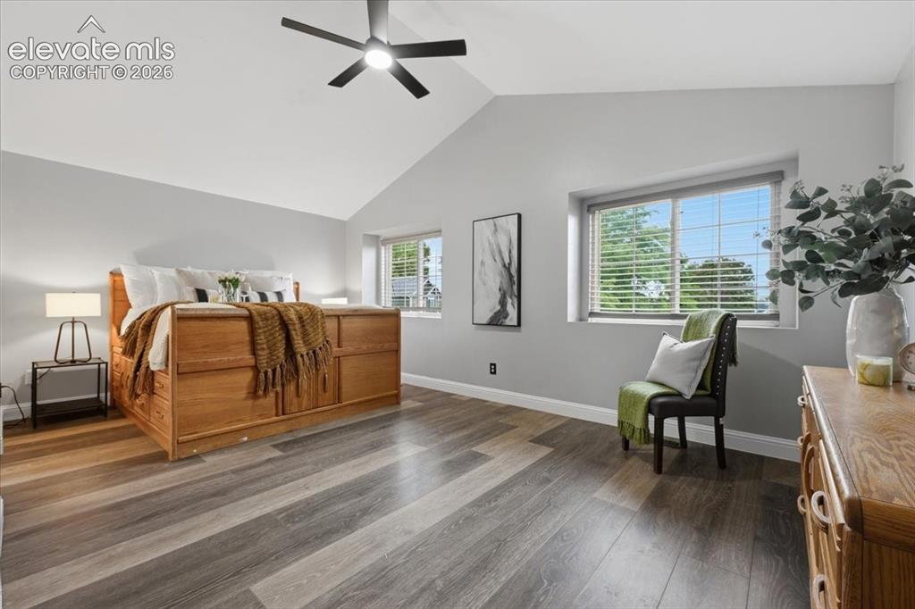 Image 23 of 50: Private master retreat with plank flooring, vaulted ceiling and sitting are