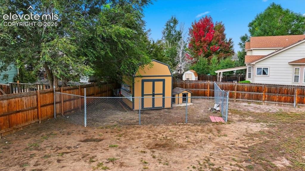 Image 46 of 50: Huge side yard with shed, dog run and drainage pipe for concrete patio for 
