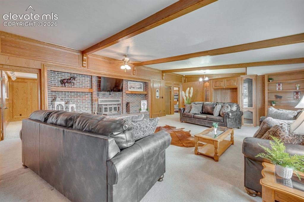 Image 9 of 20: Spacious living room featuring brick wall/fireplace
