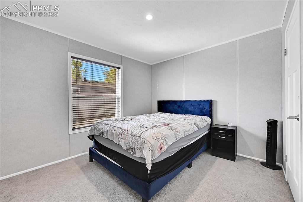 Image 11 of 12: Bedroom with crown molding, light colored carpet, and baseboards