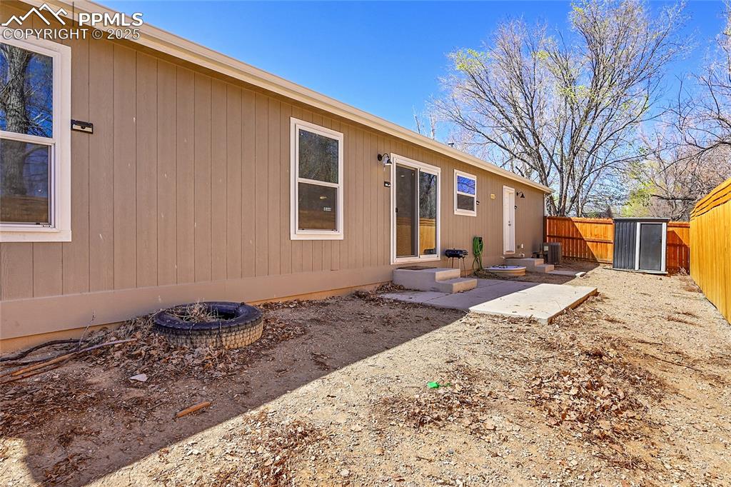 Image 12 of 12: Rear view of property with entry steps and fence