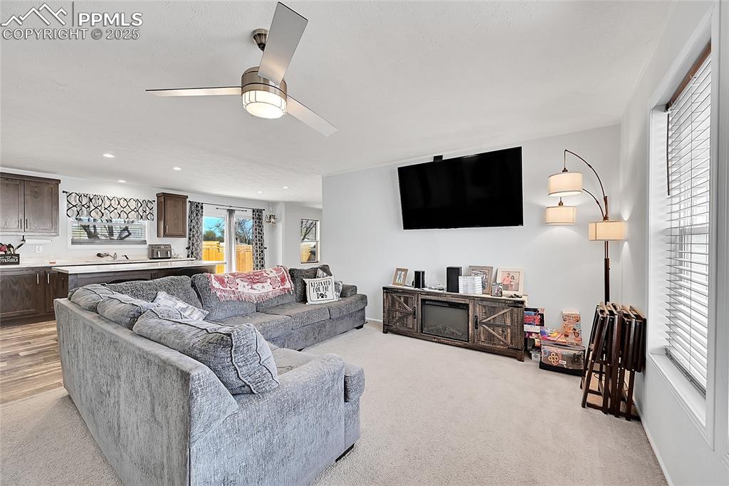 Image 2 of 12: Living room with light carpet, a ceiling fan, and recessed lighting