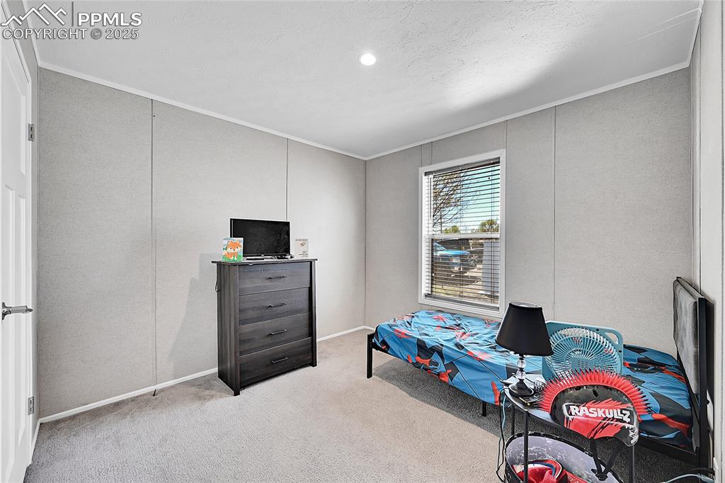 Image 9 of 12: Carpeted bedroom featuring crown molding and baseboards