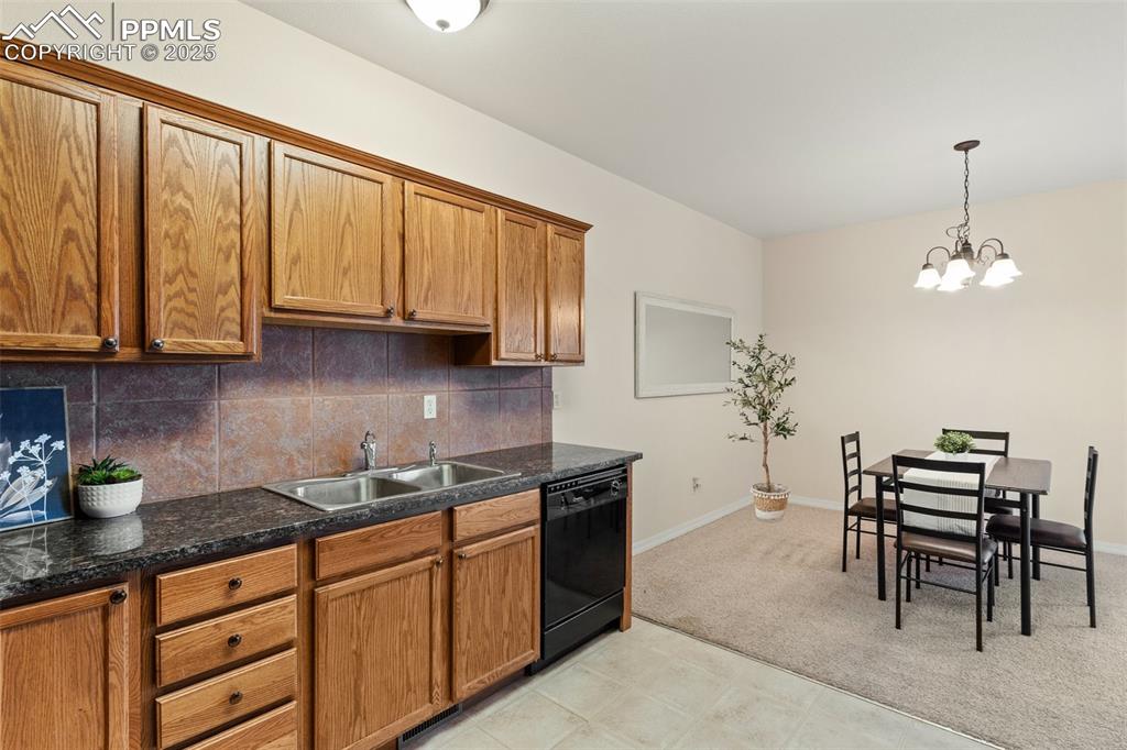 Image 11 of 27: Kitchen featuring tasteful backsplash, brown cabinets, and dishwasher