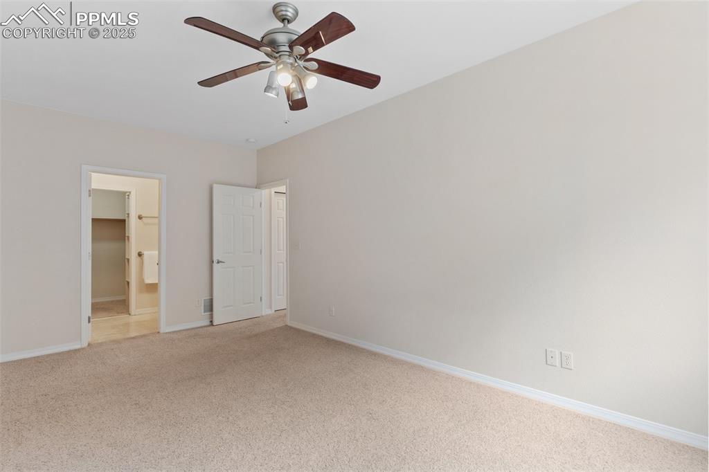 Image 16 of 27: Unfurnished bedroom with carpet floors, ceiling fan, and ensuite bathroom