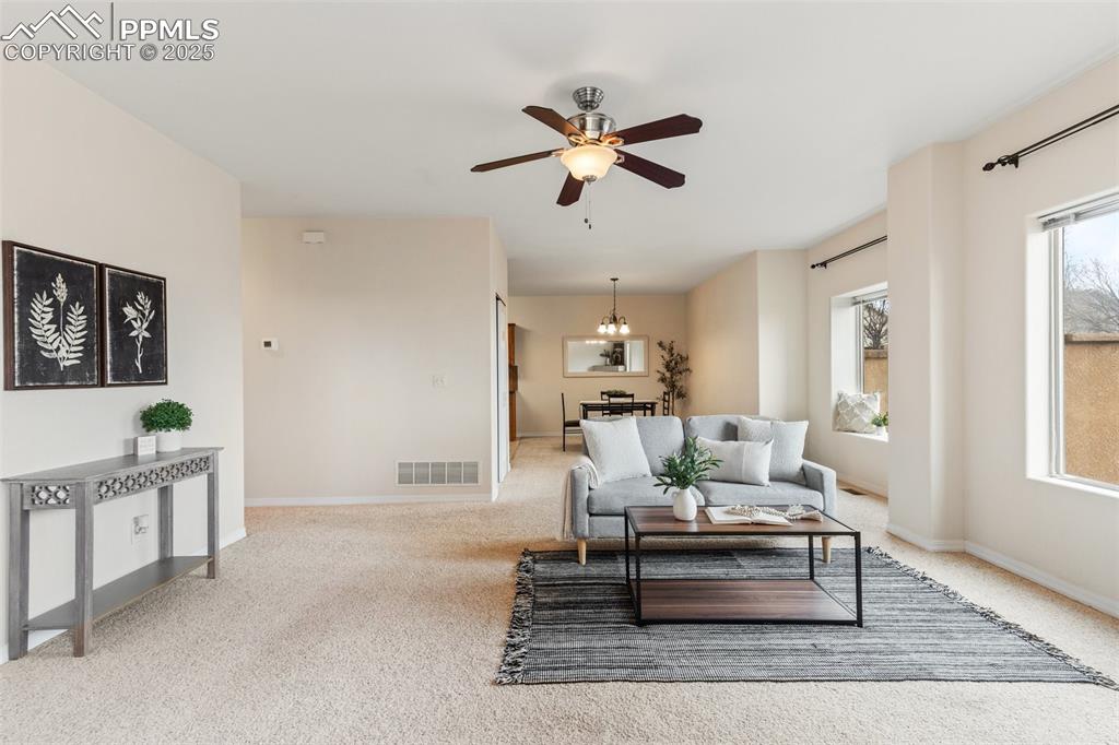 Image 3 of 27: Living area with a ceiling fan and light carpet