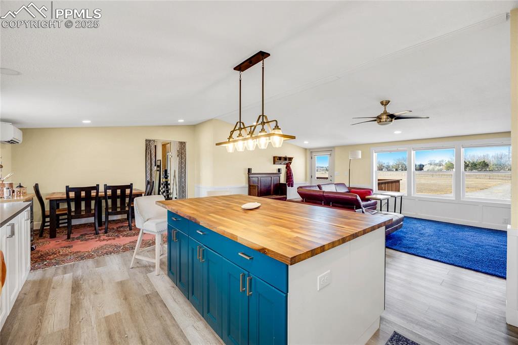 Image 13 of 49: Kitchen featuring butcher block countertops, a kitchen island, blue cabinet