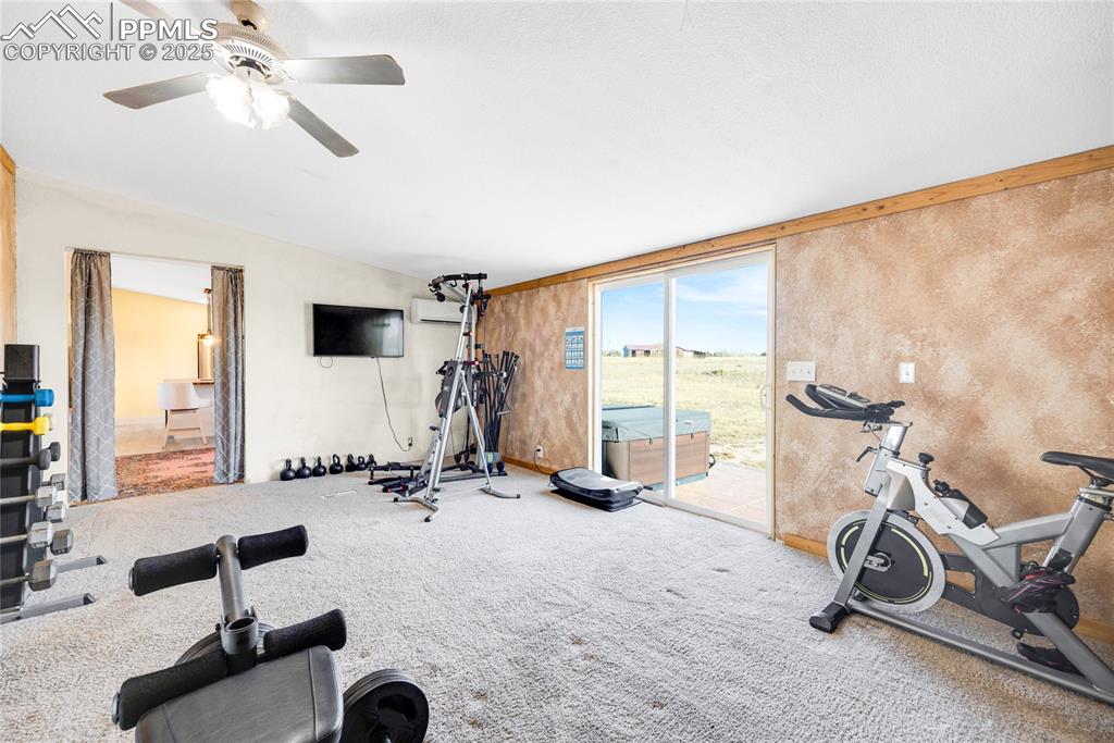 Image 24 of 49: Workout room with carpet, vaulted ceiling, and an AC wall unit