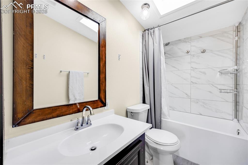Image 28 of 49: Full bath featuring shower / tub combo, vanity, and a skylight
