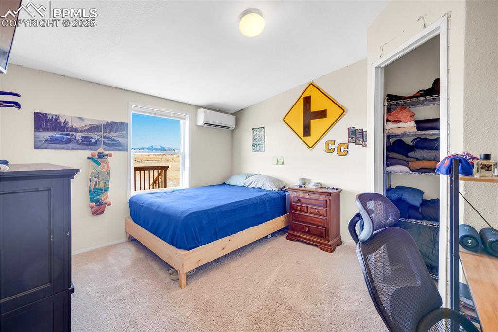 Image 29 of 49: Carpeted bedroom with a closet and a wall mounted air conditioner