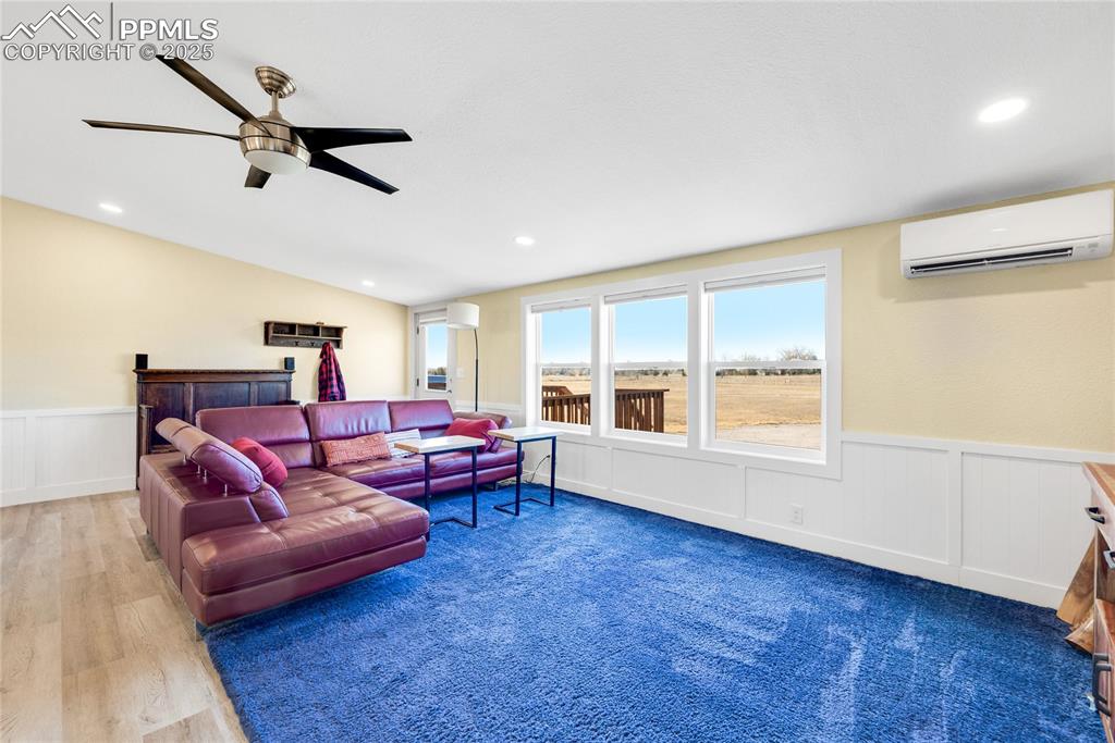 Image 3 of 49: Living area featuring a wainscoted wall, a wall mounted air conditioner, a 
