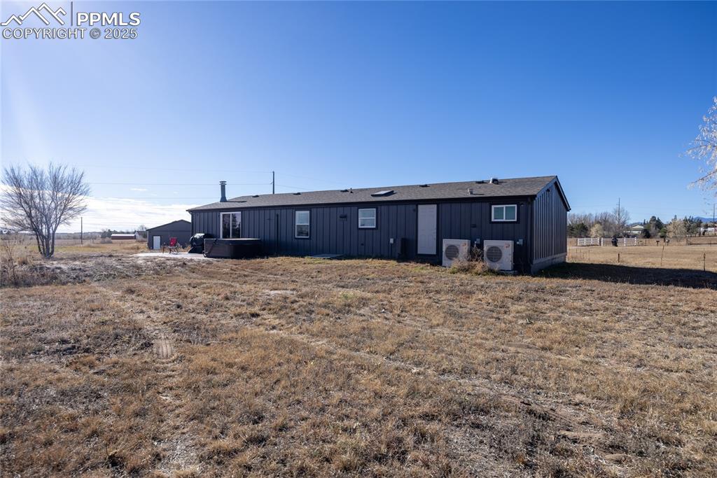 Image 32 of 49: Back of house with board and batten siding and a patio area
