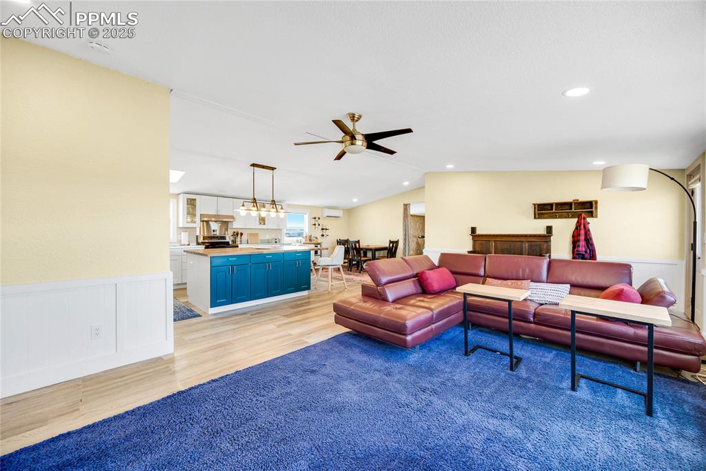 Image 4 of 49: Living area featuring a wainscoted wall, light wood-style flooring, recesse