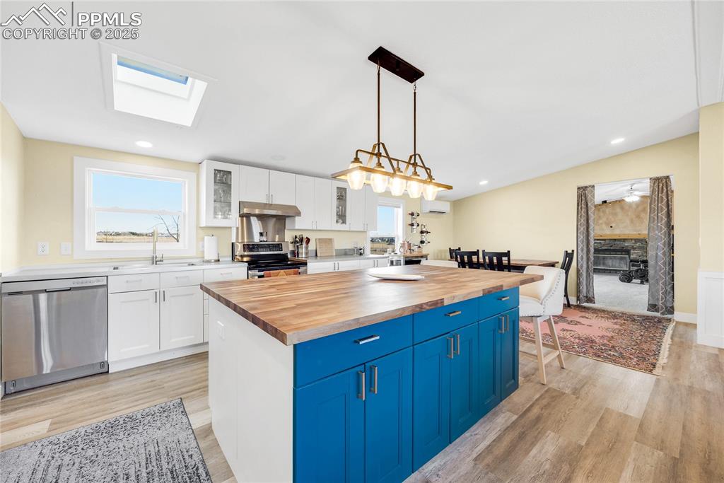 Image 6 of 49: Kitchen featuring glass insert cabinets, white cabinets, butcher block coun