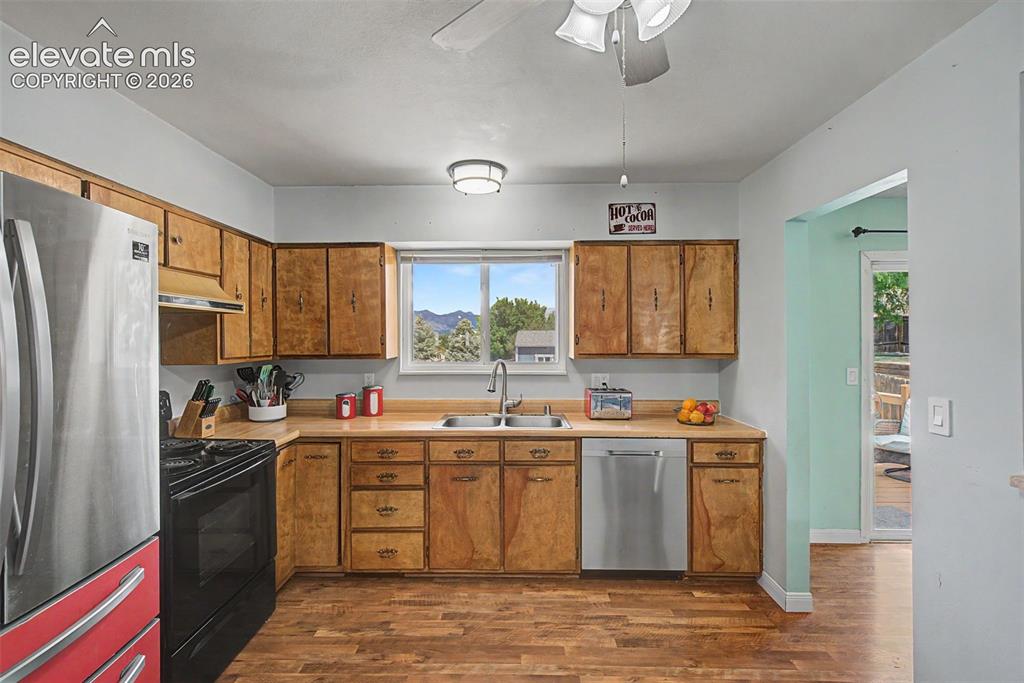 Image 11 of 30: Kitchen featuring wood-finish flooring and cabinetry, stainless steel appli