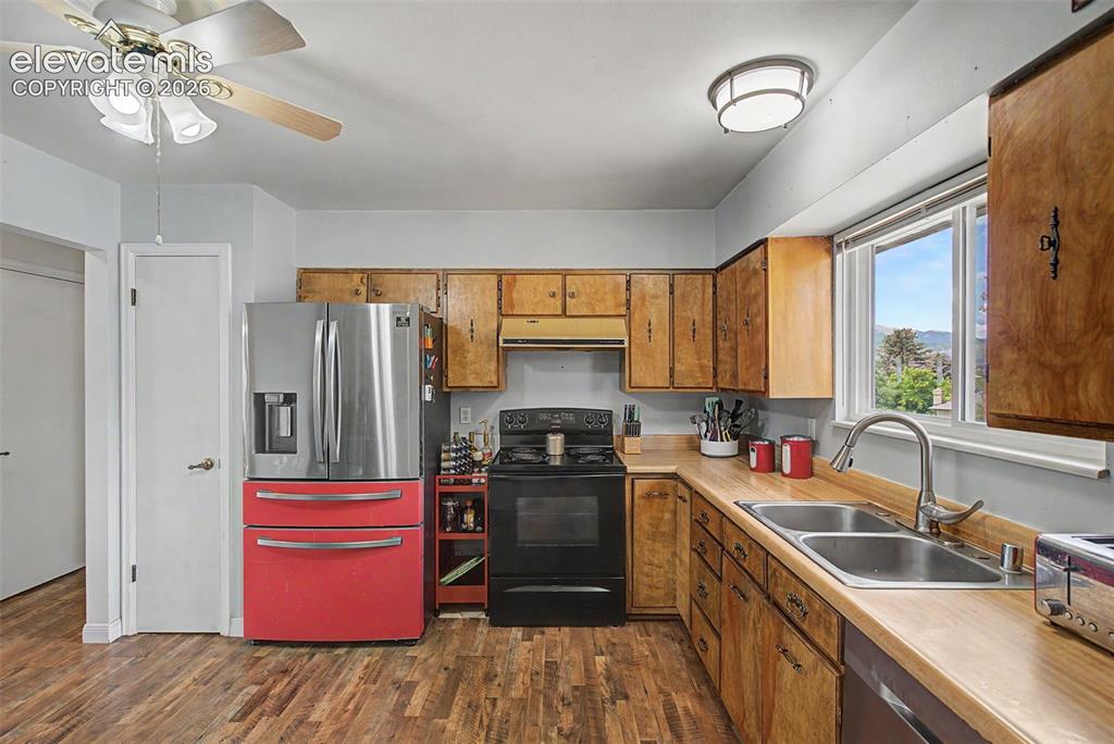 Image 12 of 30: Kitchen featuring wood-finish flooring, a double basin stainless steel sink