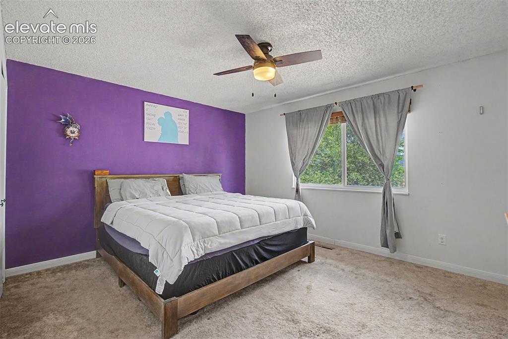 Image 15 of 30: Bedroom featuring a window with abundant natural light, a ceiling fan with