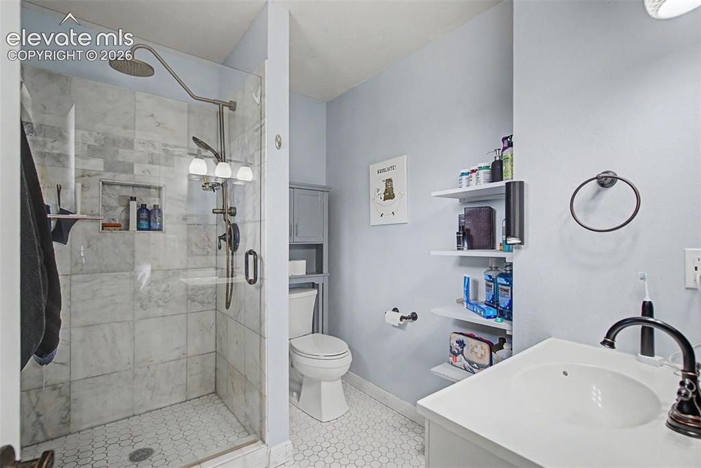 Image 17 of 30: Modern bathroom featuring a glass-enclosed shower with large format tile su