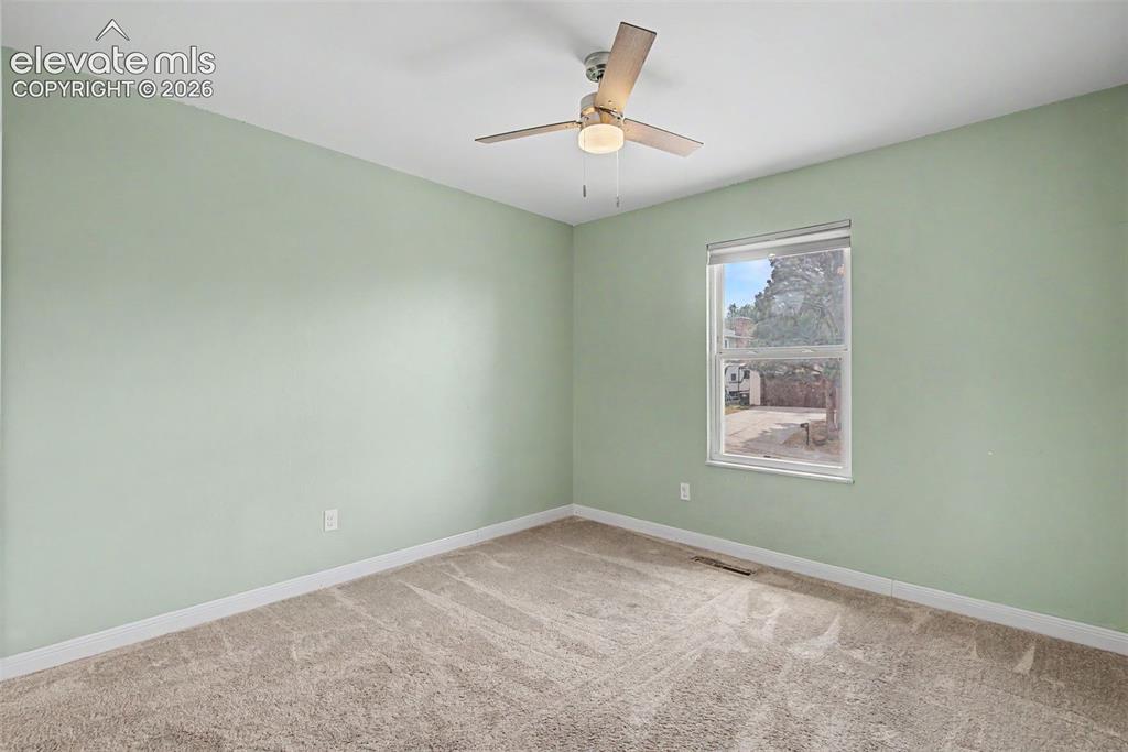 Image 19 of 30: Room with light green painted walls, neutral carpet flooring, and white bas