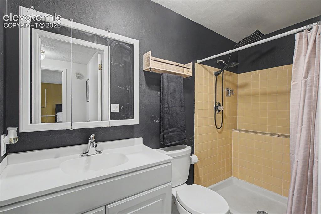 Image 27 of 30: Bathroom featuring a vanity with an integrated sink, a medicine cabinet wit