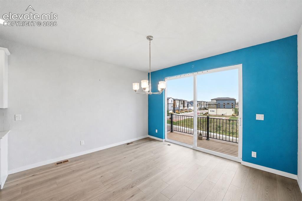 Image 10 of 23: Sliding glass door, wood-finish flooring, recessed ceiling lighting, contem