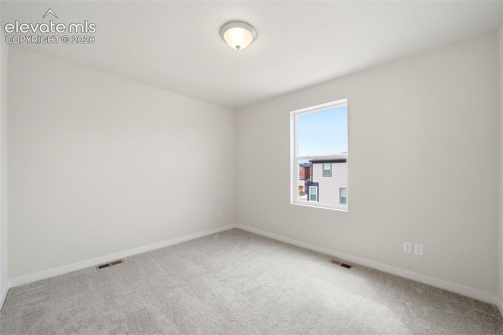 Image 12 of 25: Bedroom -2 Neutral gray walls and light gray carpeting create a versatile i