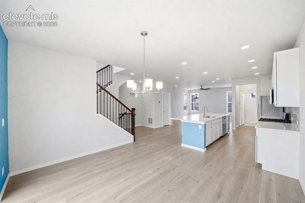 Image 4 of 23: Open-concept living space featuring wood-finish flooring, a kitchen island 