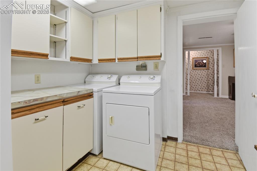 Image 27 of 47: basement laundry with cabinets and closet
