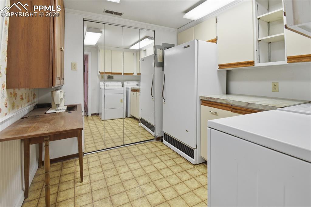 Image 28 of 47: basement laundry with cabinets and closet
