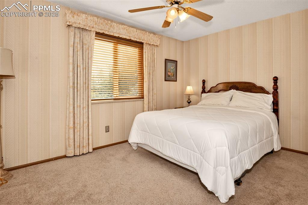Image 12 of 36: Warm decor and ceiling fan in the primary bedroom