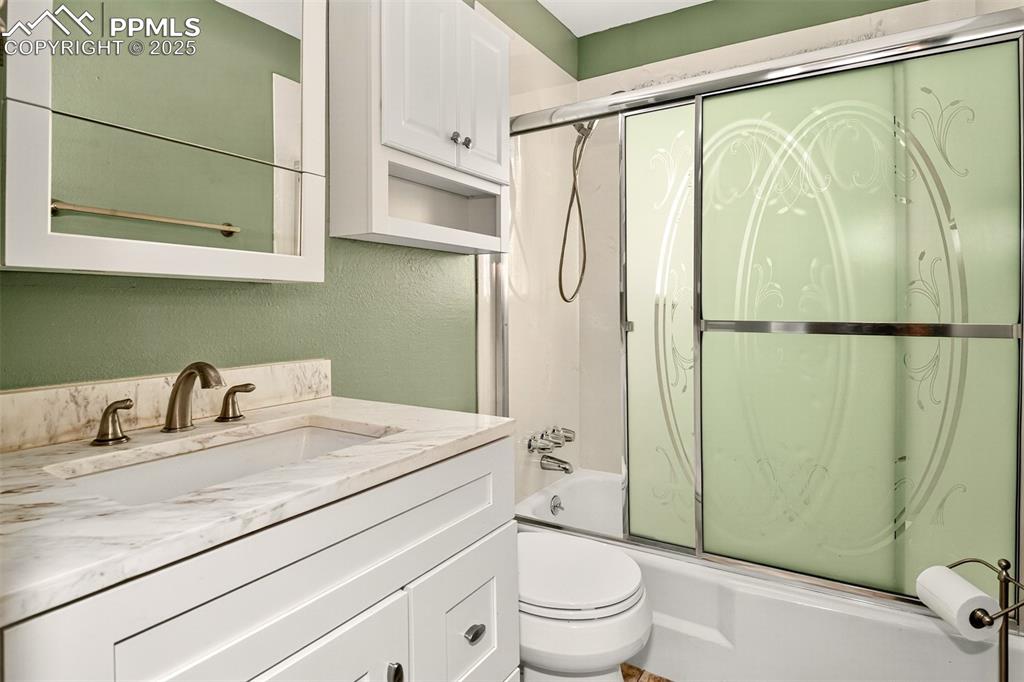 Image 14 of 36: Main level full bathroom with quartz vanity and tub/shower combo