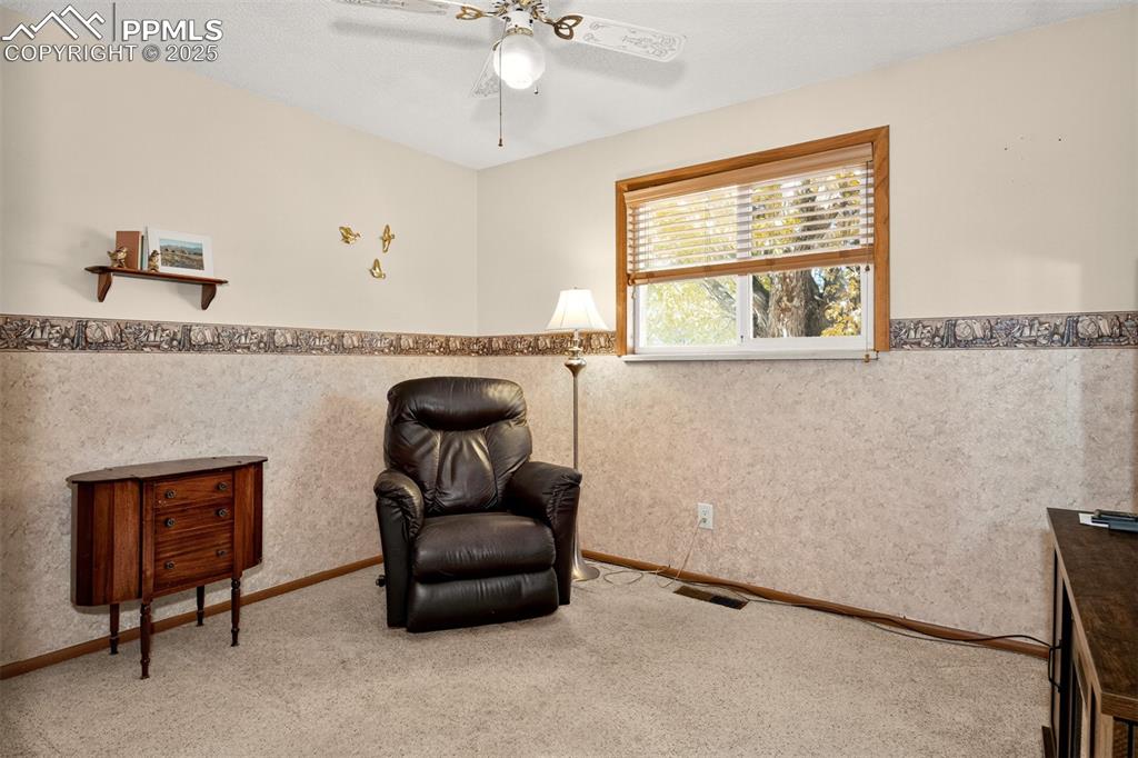 Image 15 of 36: Second main level bedroom with decorative ceiling fane and wallpaper